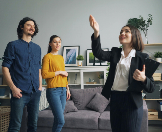 Real estate agent using a smartphone to manage Instagram Reels and DMs in a modern kitchen setting. Concept of 2026 digital property marketing.