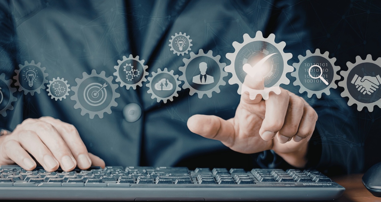 Digital illustration of a professional working at a computer keyboard, with a series of interconnected gears floating above, symbolizing a streamlined business strategy with icons for ideation, targeting, cloud processing, personalization, and a final handshake.