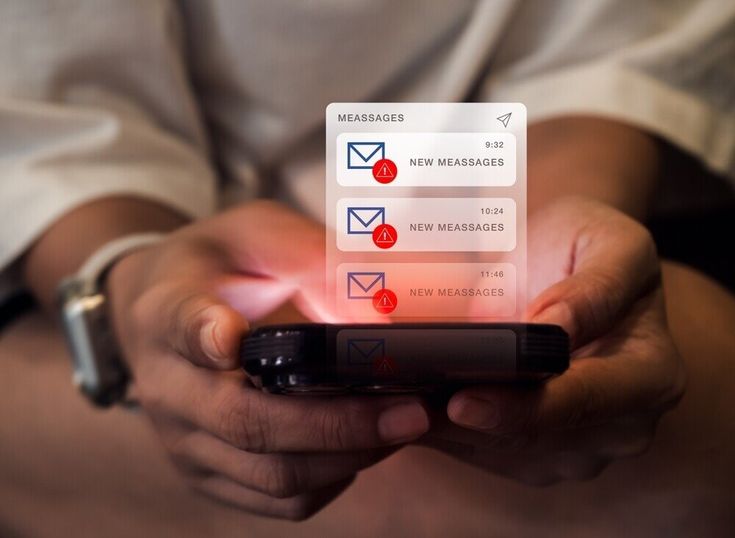 A close-up of a person's hands holding a dark smartphone horizontally. A glowing, semi-transparent digital interface floats above the screen, displaying a list of unread message notifications. The panel is titled 'MEASSAGES' and shows three stacked alerts, each featuring an envelope icon with a red notification badge, a timestamp, and the text 'NEW MEASSAGES'.