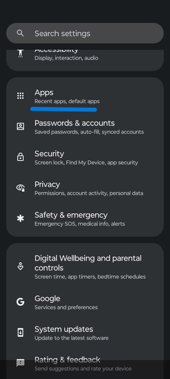 Screenshot of an Android Settings menu in dark mode with the Apps section highlighted. Other visible options include Passwords & Accounts, Security, Privacy, Safety & Emergency, Digital Wellbeing & Parental Controls, Google, System Updates, and Rating & Feedback. A search settings bar appears at the top of the screen.