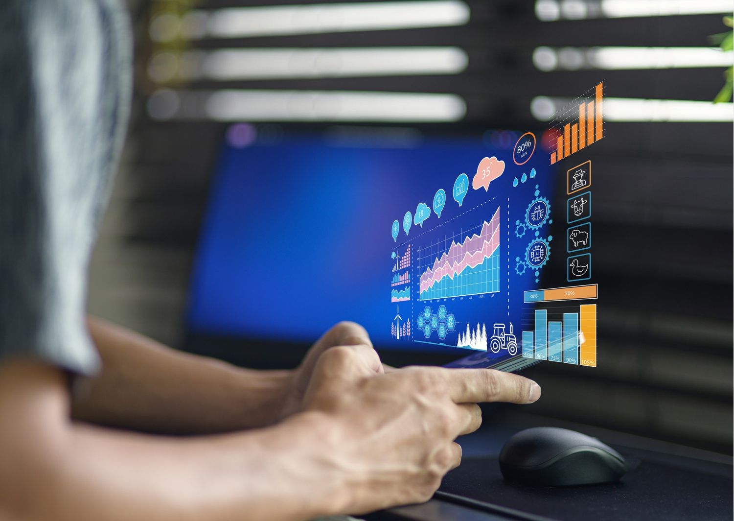 A close-up shot of a person's hands holding a smartphone that projects a glowing, three-dimensional digital interface filled with colorful data charts, analytics graphs, and technical icons.
