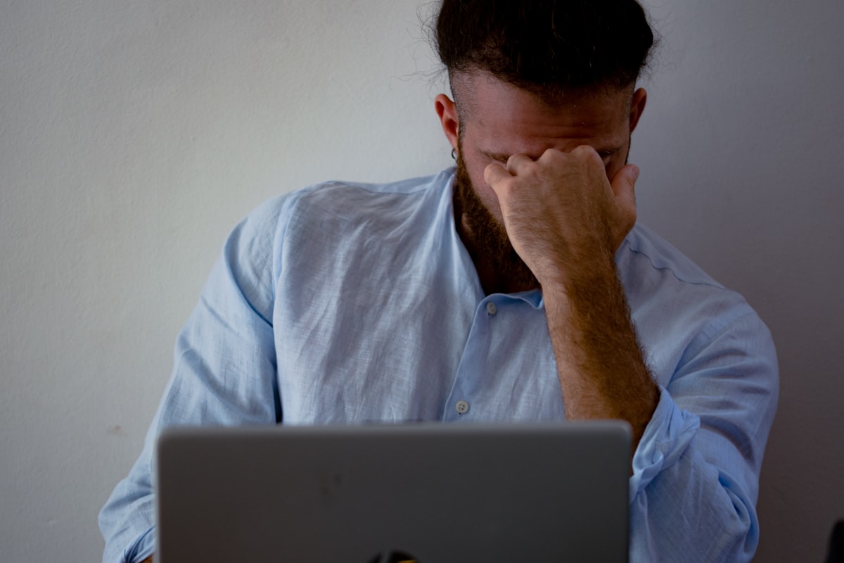 A frustrated person with their head in their hand in front of a laptop: debugging an Instagram automation that silently stopped working.