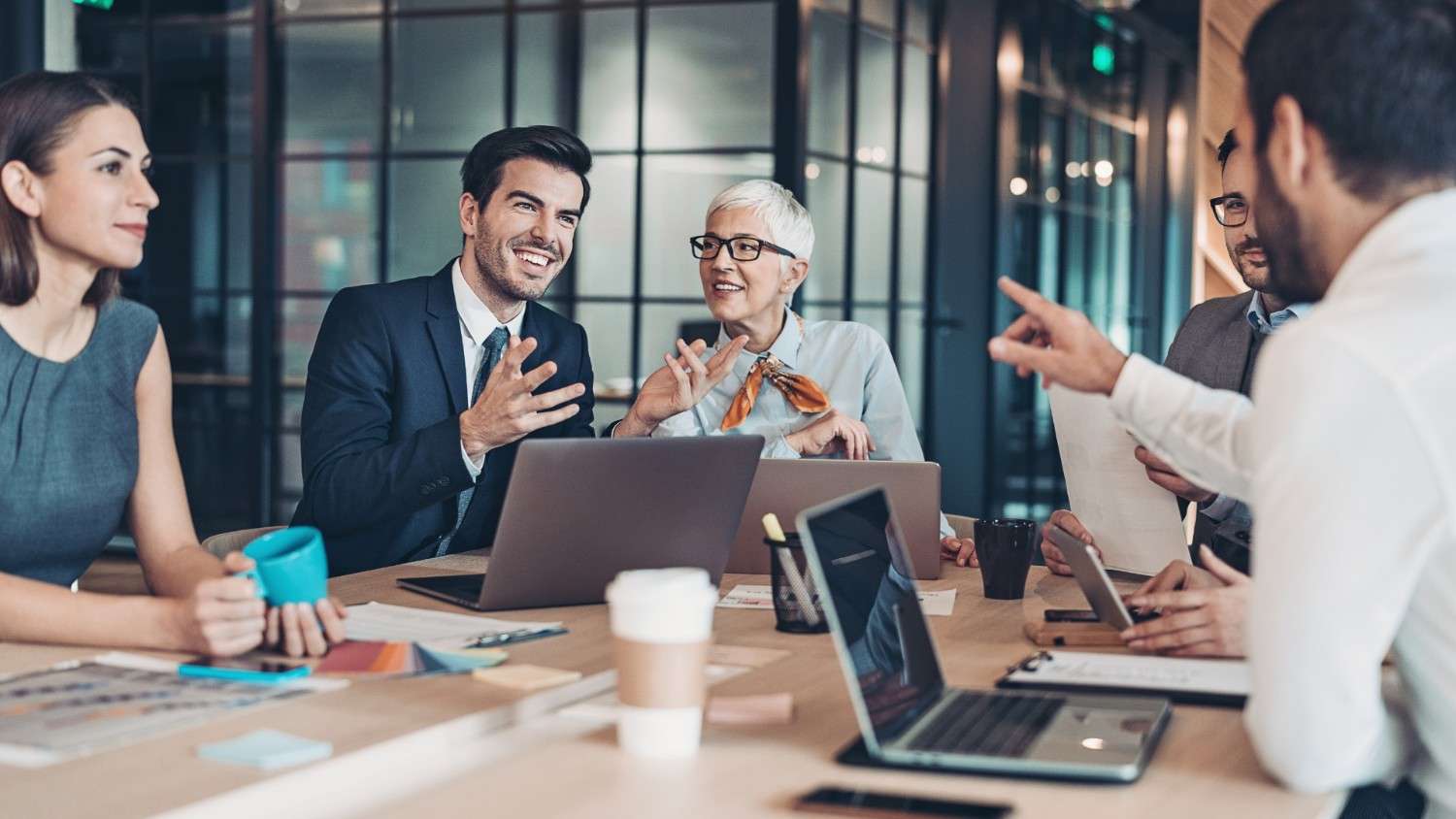 A group of business professionals having a collaborative meeting around a table in a modern office.