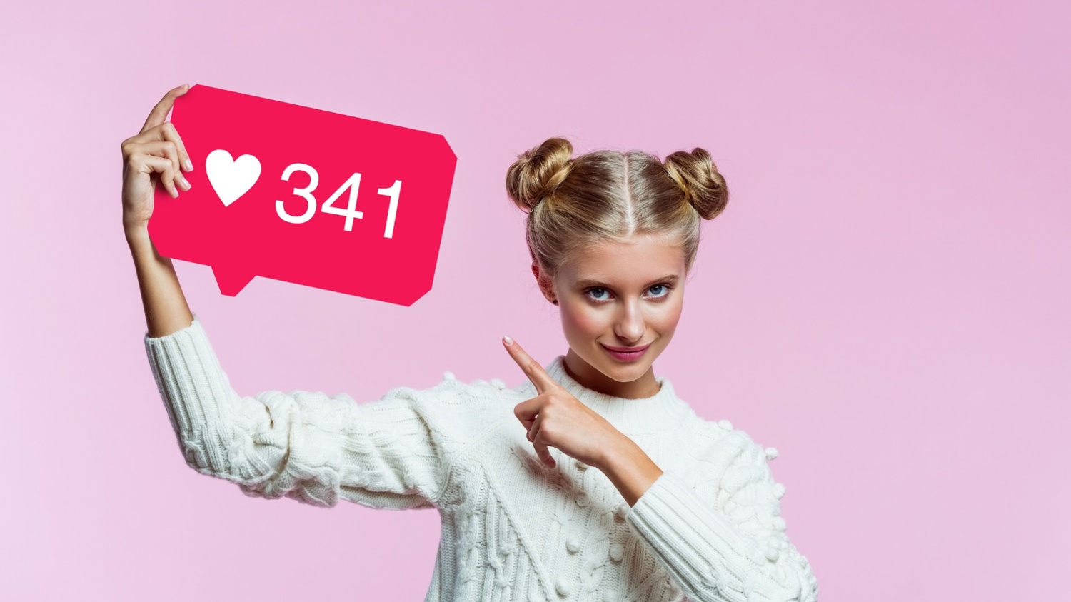A young woman with her hair in two buns holding up a pink Instagram notification bubble icon showing 341 likes while pointing at it against a solid pink background.