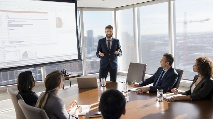 A businessman giving a presentation to colleagues in a bright, modern conference room.